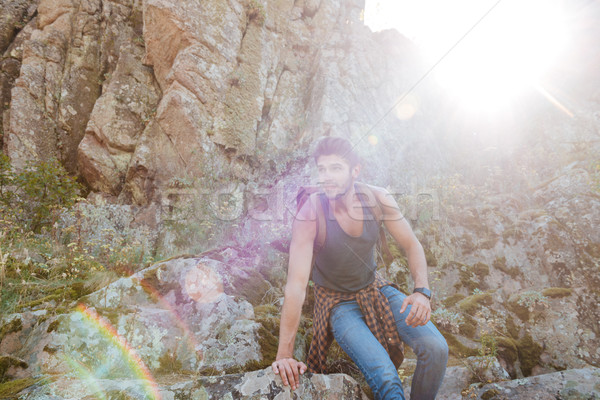 Young traveling man walking on rock Stock photo © deandrobot