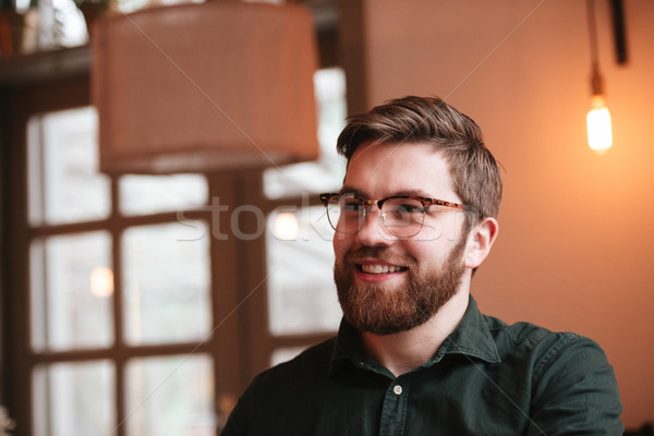 Cheerful bearded young man look aside. Stock photo © deandrobot