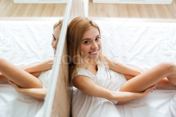 Wesoły kobieta posiedzenia lustra bed domu Zdjęcia stock © deandrobot
