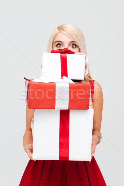 Stock photo: Woman in red dress peeking out from heap of presents