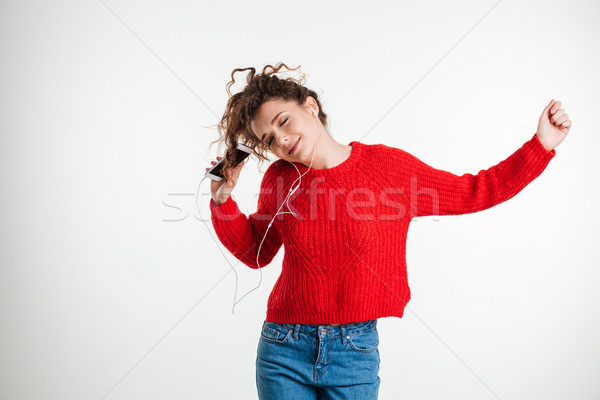 Portrait of a young curly woman with earphones Stock photo © deandrobot