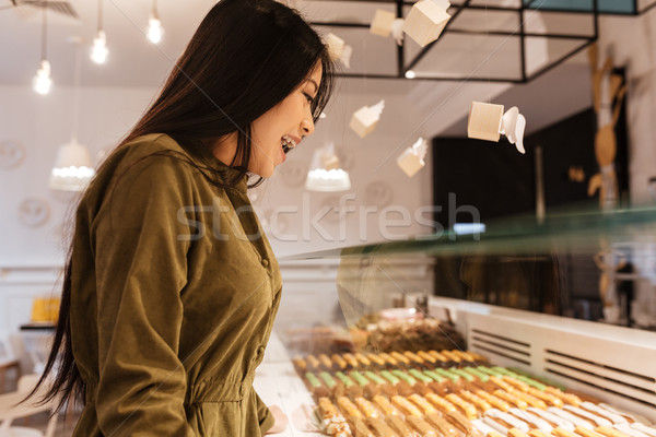 Happy asian young woman standing at the cafe. Stock photo © deandrobot