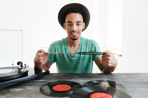 Smiling african man holding records Stock photo © deandrobot