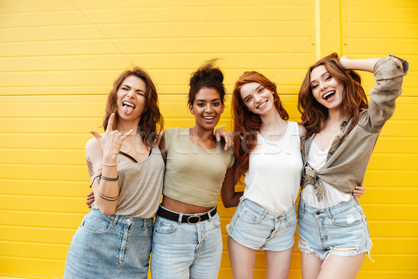Glimlachend vrouwen vrienden Geel muur naar Stockfoto © deandrobot