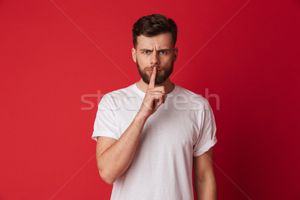 Ernstig jonge man tonen stilte gebaar afbeelding Stockfoto © deandrobot