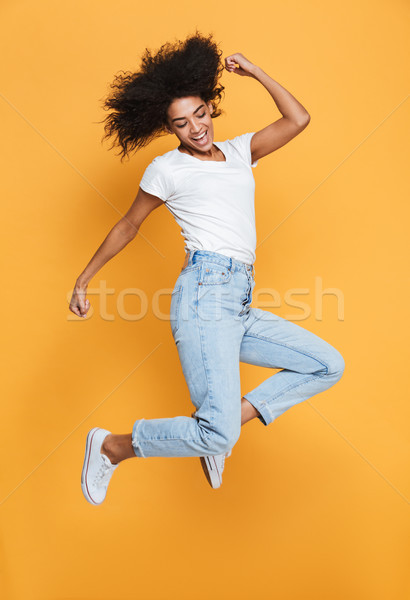 Full length portrait of a happy young african woman Stock photo © deandrobot