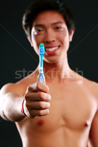 Teeth care young man with toothbrush. Focus on toothbrush Stock photo © deandrobot
