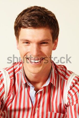 Portrait of a smiling man with curly hair over gray background Stock photo © deandrobot