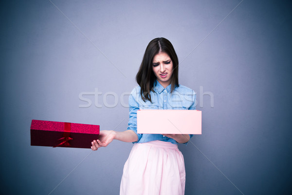Dissatisfied woman opening gift Stock photo © deandrobot