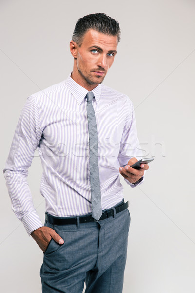 Handsome businessman using smartphone Stock photo © deandrobot