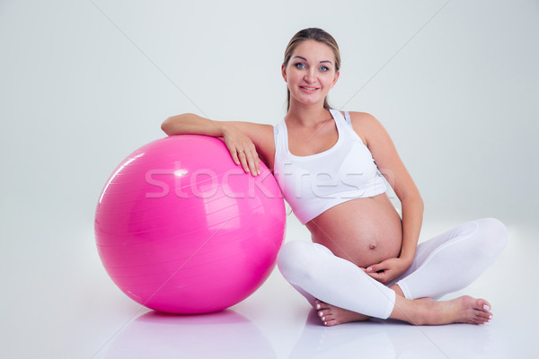 Pregnant woman sitting on the floor with fitness ball Stock photo © deandrobot