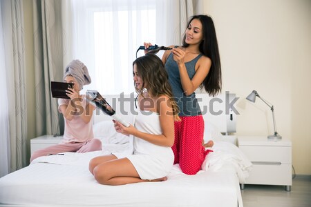 Three girlfriends doing makeup and hairstyle Stock photo © deandrobot