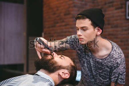 Concentrated hairstylist sprinkles with water hair of client  Stock photo © deandrobot