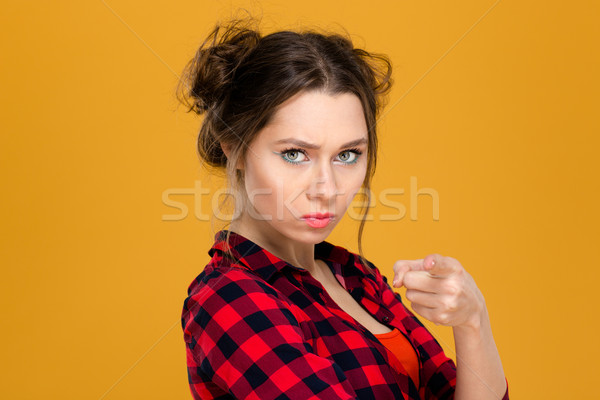 Stock photo: Angry irritated young woman in plaid shirt pointing on you
