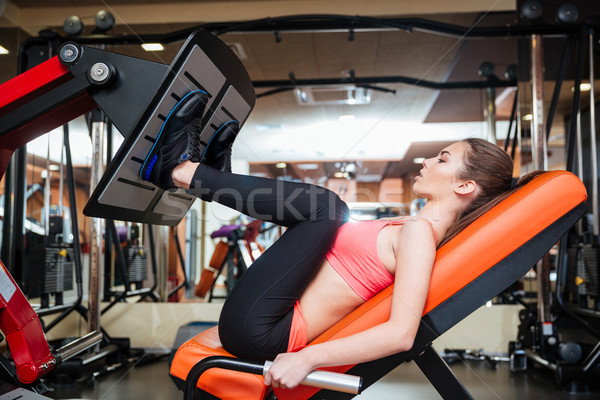 Strong sportswoman doing fitness exercises for legs muscles in gym  Stock photo © deandrobot