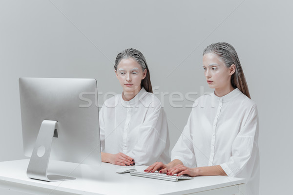 Two women sitting at the table with computer, pc Stock photo © deandrobot