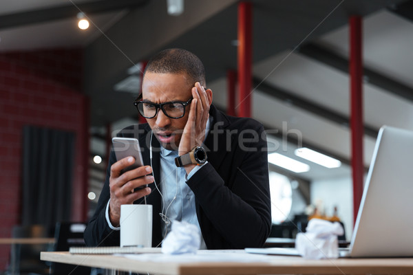 Businessman looking at the smartphone Stock photo © deandrobot