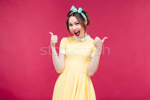Cheerful excited pinup girl showing thumbs up Stock photo © deandrobot
