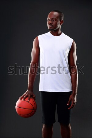 Full length portrait of a sports woman holding basketball ball Stock photo © deandrobot