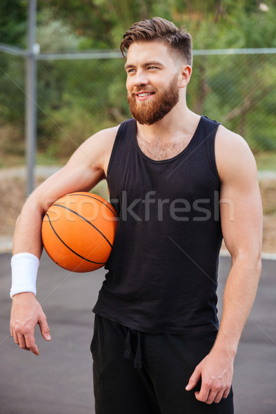 Cheerful happy basketball player standing with ball Stock photo © deandrobot