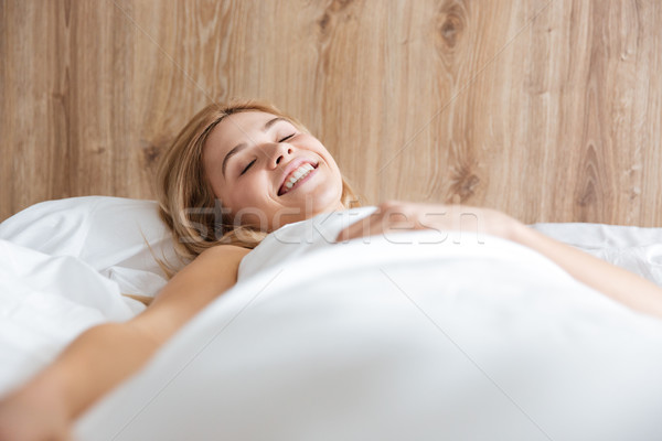 Mosolygó nő ágy csukott szemmel hálószoba haj otthon Stock fotó © deandrobot