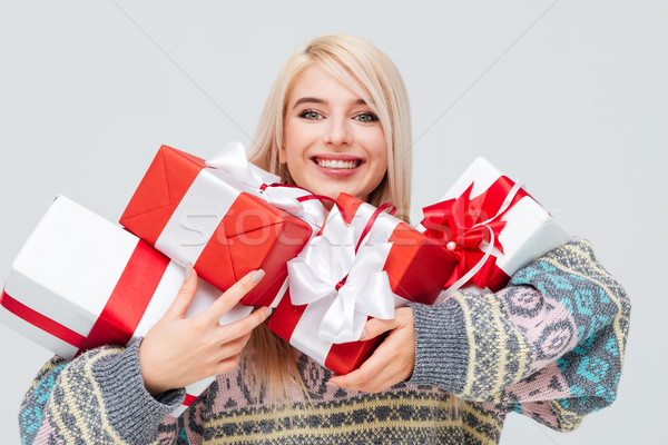 Woman holding heap of gift boxes and looking at camera Stock photo © deandrobot