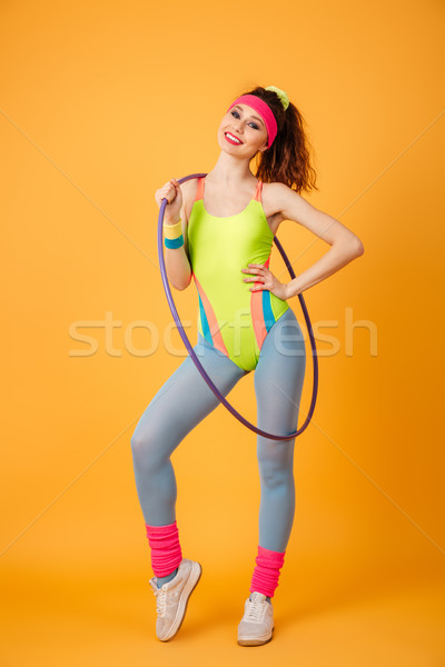 Happy young woman athlete with hula hoop standing and posing Stock photo © deandrobot
