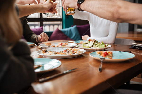 Cropped photo of friends eating and drinking alcohol. Stock photo © deandrobot