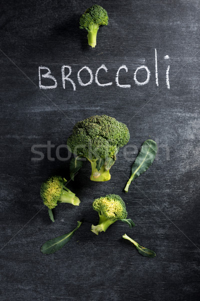 Photo of broccoli over dark chalkboard background. Stock photo © deandrobot