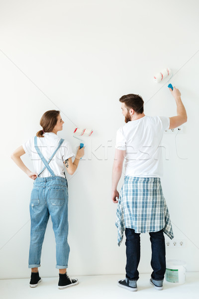 Full length back view of young beautiful couple painting Stock photo © deandrobot