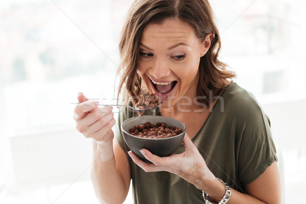 Happy casual woman eating from plate Stock photo © deandrobot