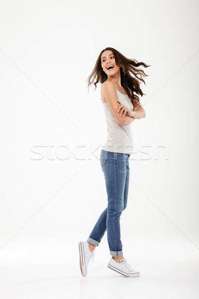 Full length image of Cheerful brunette woman posing sideways Stock photo © deandrobot