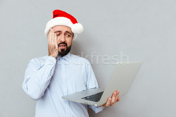 Stock photo: Confused Bearded man in business clothes and christmas hat