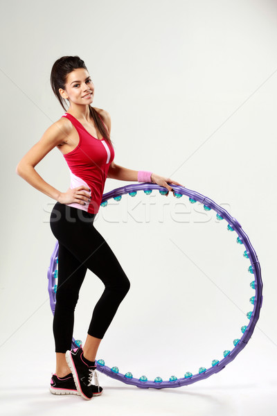 Young happy woman standing with message hoop on gray background Stock photo © deandrobot