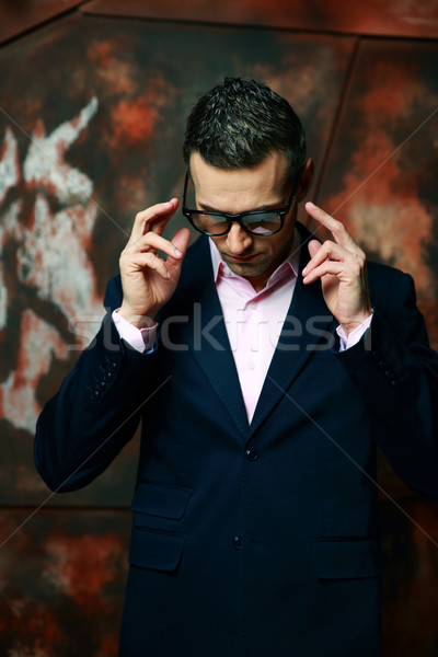 Cool fashion man in glasses standing over industrial background Stock photo © deandrobot