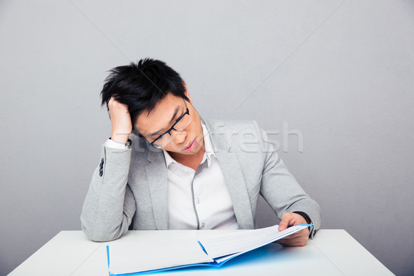 Businessman reading papers in office Stock photo © deandrobot