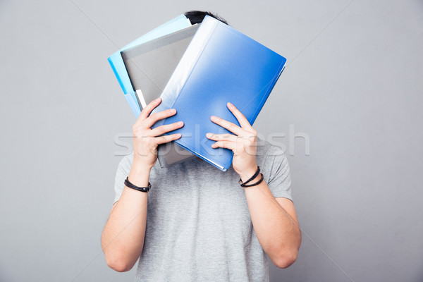 Man covering his face with folders Stock photo © deandrobot