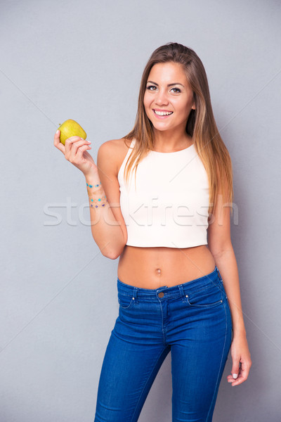 Smiling young girl holding green apple  Stock photo © deandrobot