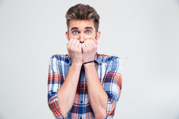 Portrait of a scared young man looking at camera  Stock photo © deandrobot