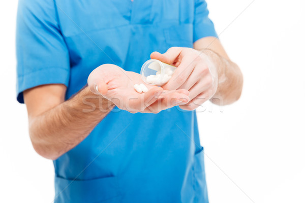 Male doctor holding pills Stock photo © deandrobot