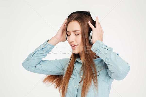 Pretty inspired woman in headphones listening to music and dancing  Stock photo © deandrobot