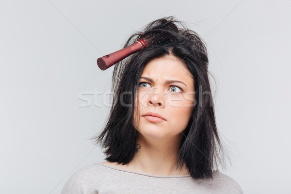 Pretty girl making funny faces with comb in hair Stock photo © deandrobot