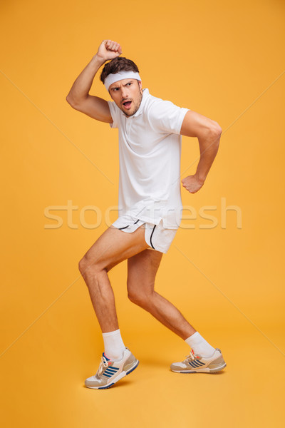 Teljes alakos vicces fiatal áll pózol citromsárga Stock fotó © deandrobot