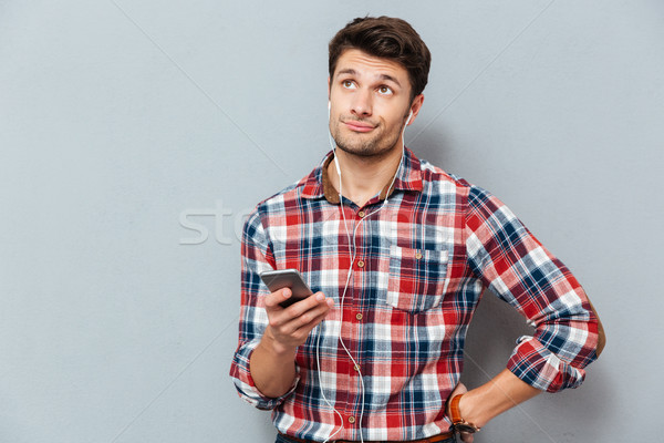 Verärgert verwirrt Mann Kopfhörer Musik hören Smartphone Stock foto © deandrobot