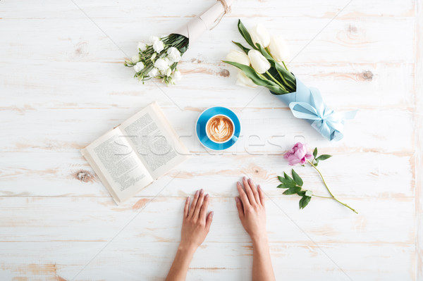 Female hands spreading over wooden table Stock photo © deandrobot