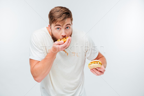 Funny hungry bearded man eating junk food Stock photo © deandrobot