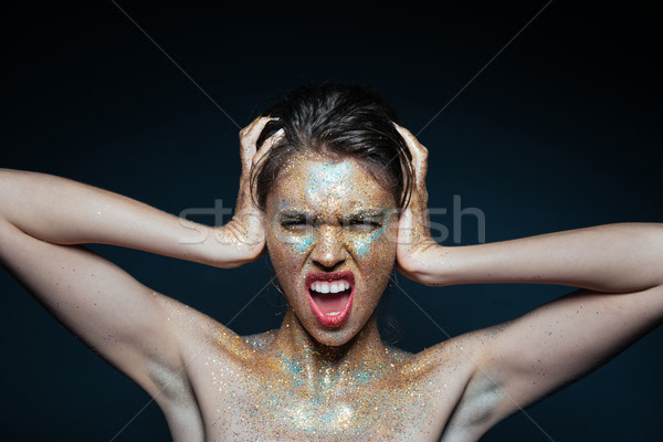 Mad young woman with shimmering makeup standing and shouting Stock photo © deandrobot