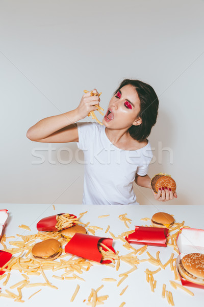 Femeie mananca franceza cartofi prajiti tabel fast food destul de Imagine de stoc © deandrobot