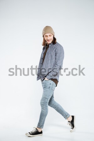 Vertical image of Smiling Hipster walking in studio Stock photo © deandrobot