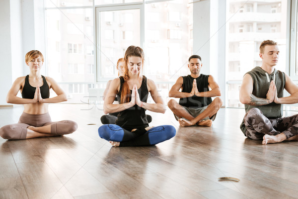 Grup de oameni şedinţei meditativ yoga studio Imagine de stoc © deandrobot